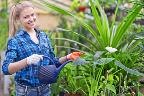 Gardener carrying out safe garden maintenance with protective equipment